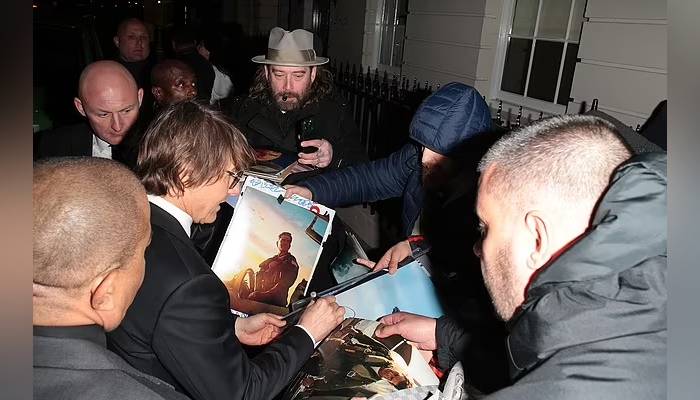 Tom Cruise in good spirits surrounded by fans outside Victoria Beckhams birthday bash